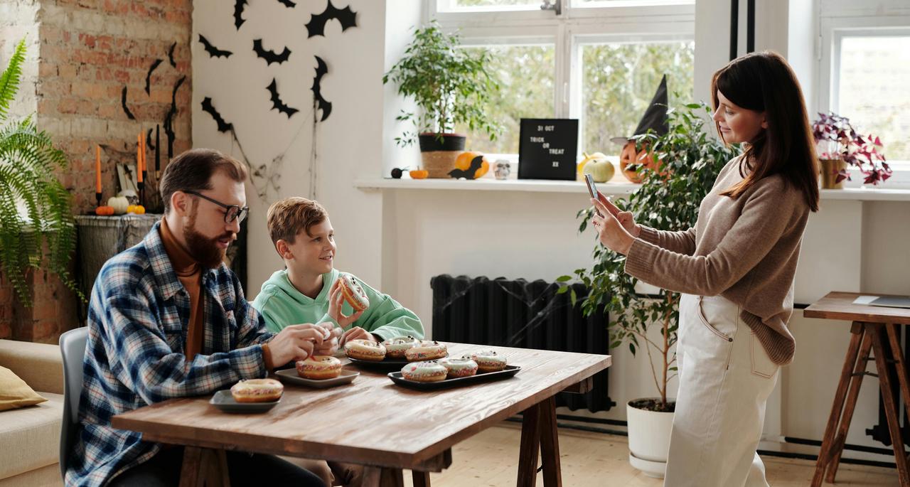 porodica za stolom uz krofne i prirodno svetlo